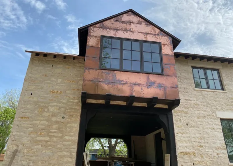 Copper metal panel facade on a stone building for Skylight Installation in Fort Dodge